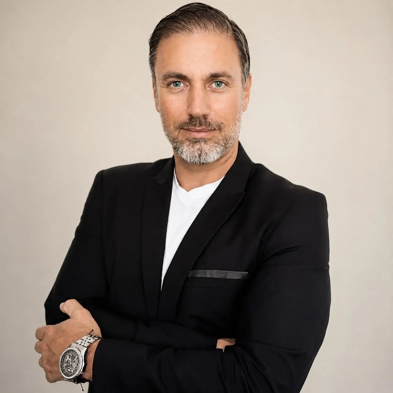 Portrait of Héctor De Castro in a black jacket and white shirt, arms folded