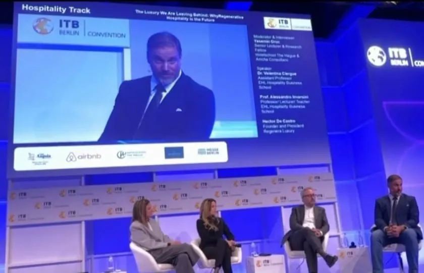 ITB Berlin Convention stage, Hospitality Track: four panellists seated beneath a screen showing Héctor De Castro speaking and the session title “The Luxury We Are Leaving Behind”