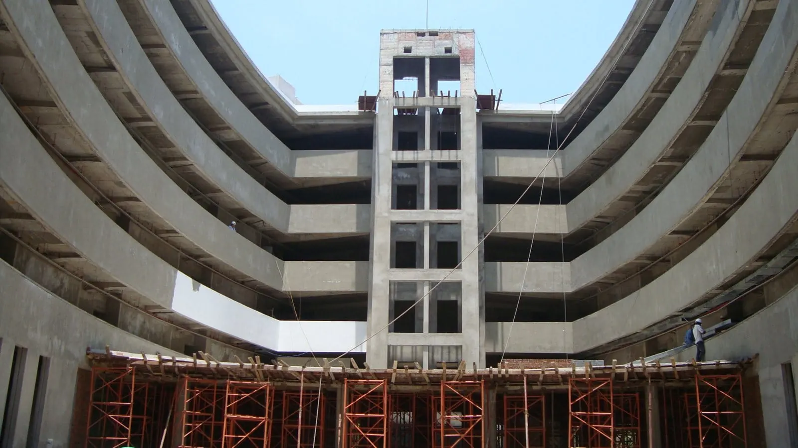The curved atrium of Meliá Danang under construction, with scaffolding and an open lift core