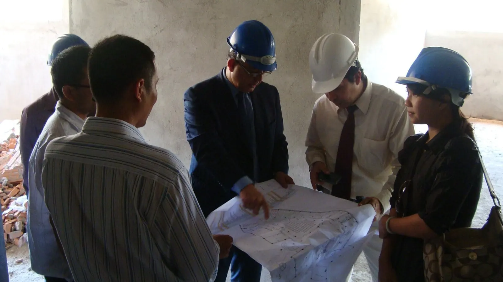 Héctor De Castro in a hard hat reviewing construction plans with the project team inside the Meliá Danang building site, Vietnam