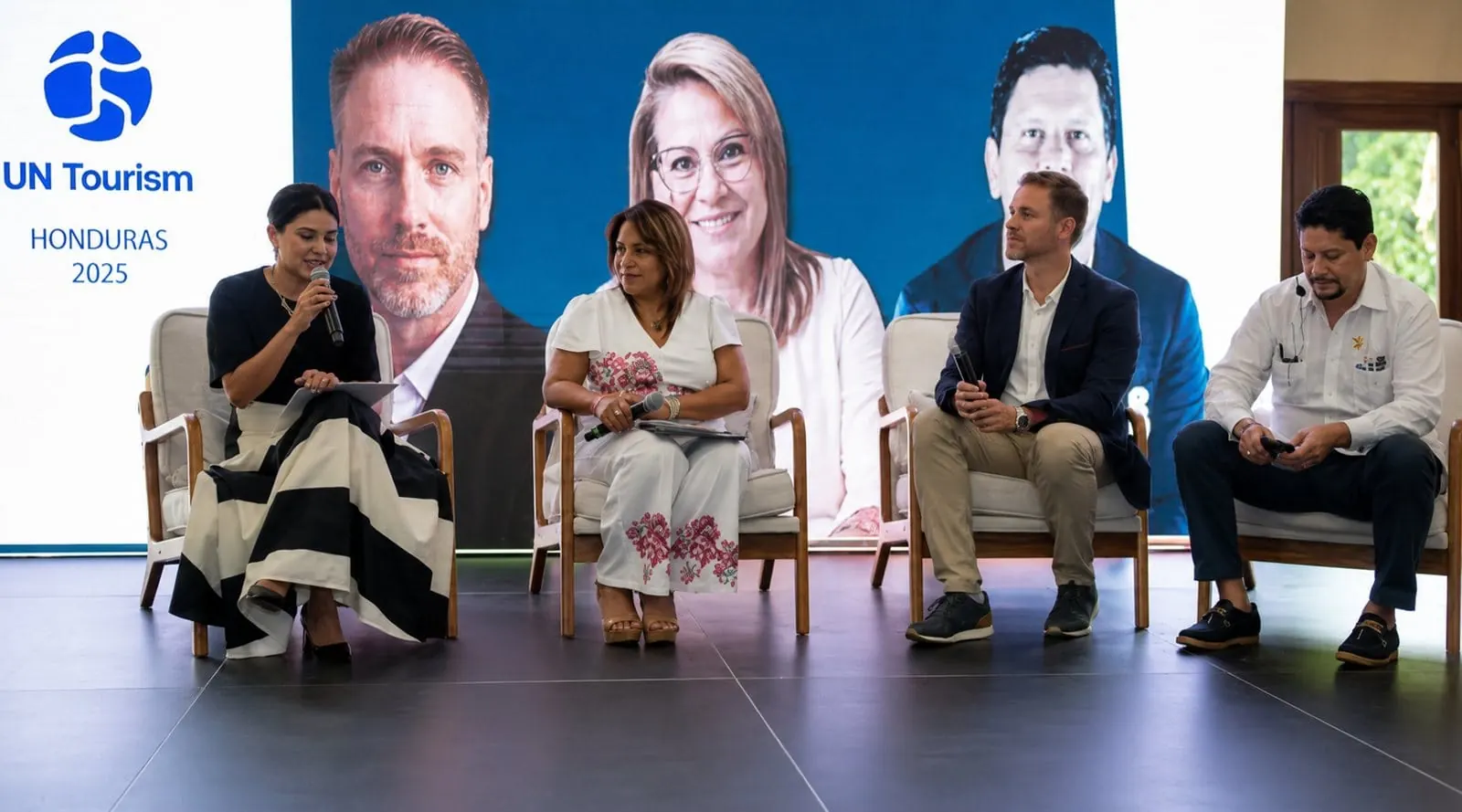UN Tourism panel in Honduras, 2025: Héctor De Castro seated with three other panellists in front of a large screen