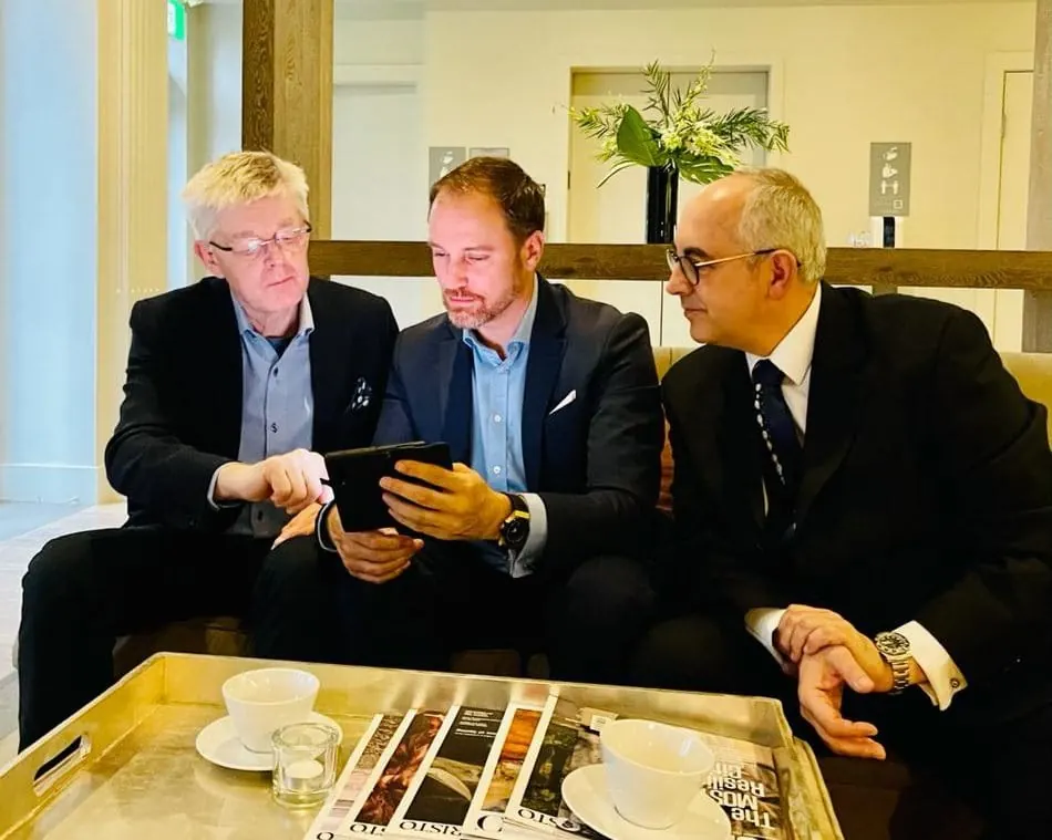 Héctor De Castro reviewing material on a tablet with Andrew Gibson and José Antonio Sáez at the Vancouver Yacht Club